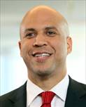 A headshot of Senator Cory Booker, who is wearing a black suit with a white shirt and red tie