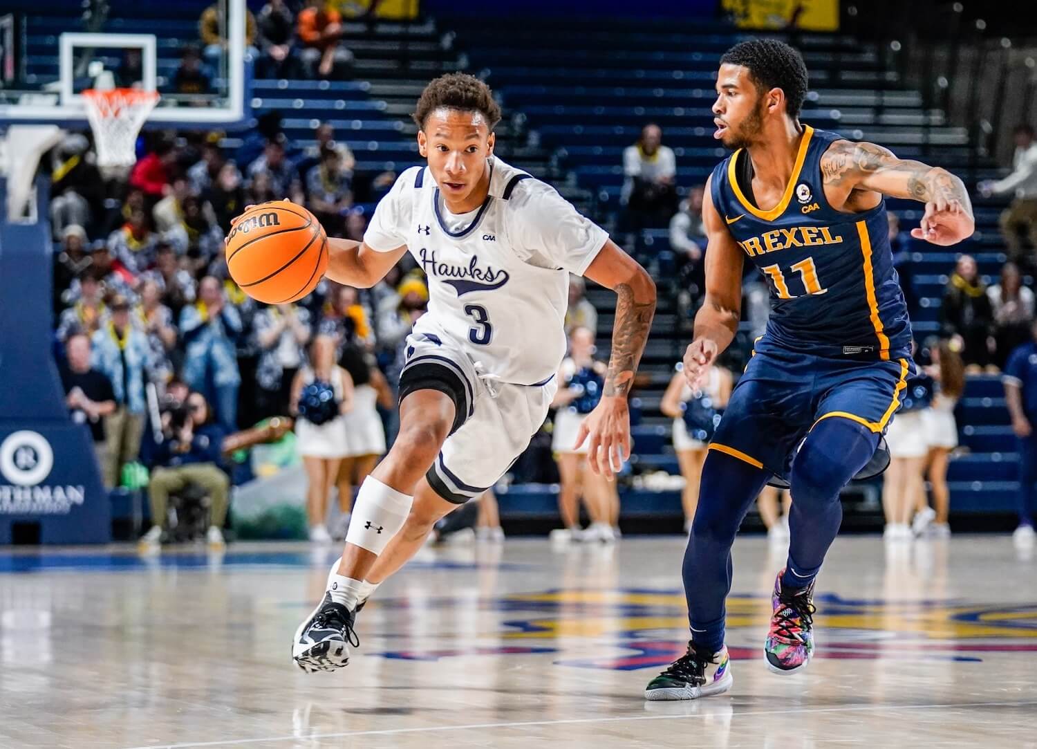 Hawks basketball player dribbling a ball while a Drexel player stays in his area