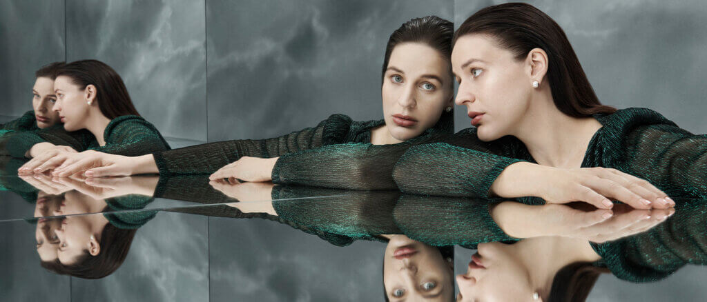 A woman looking into her reflection.