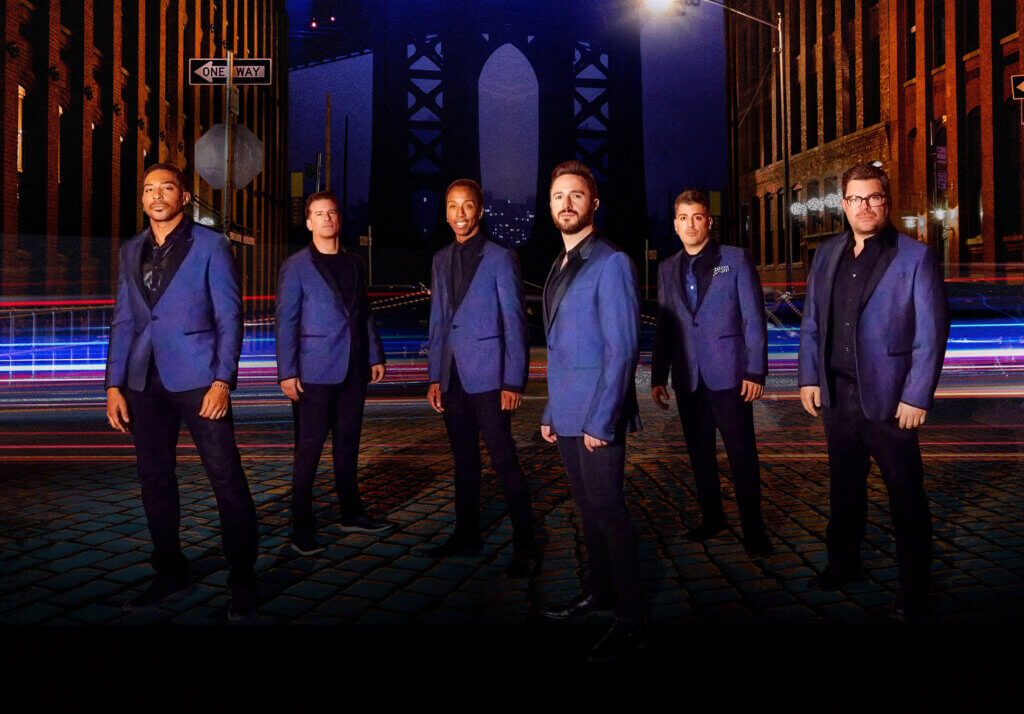 A photo of the The Doo Wop Project band members wearing purple suits.