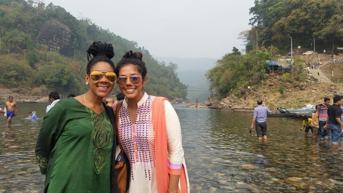 Two women posing for a shot in a body of water