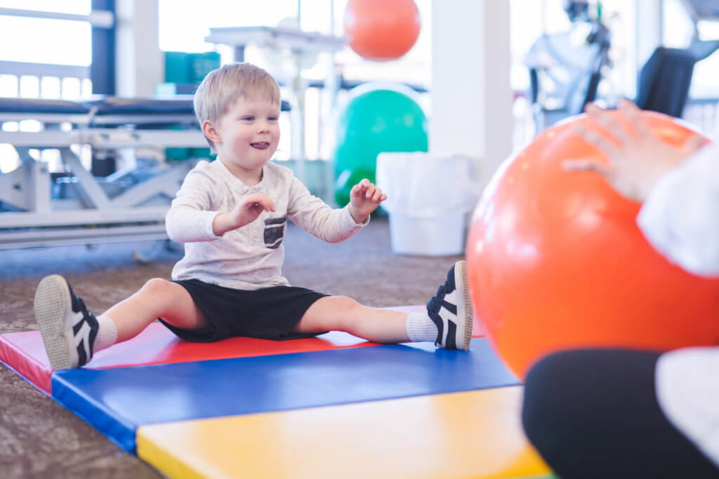 Photo of young child on exercise mat during therapy session