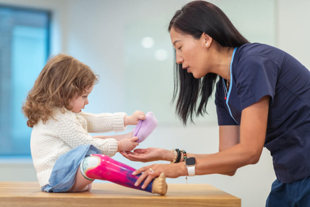 Photo shows Occupational Therapist working with young child.