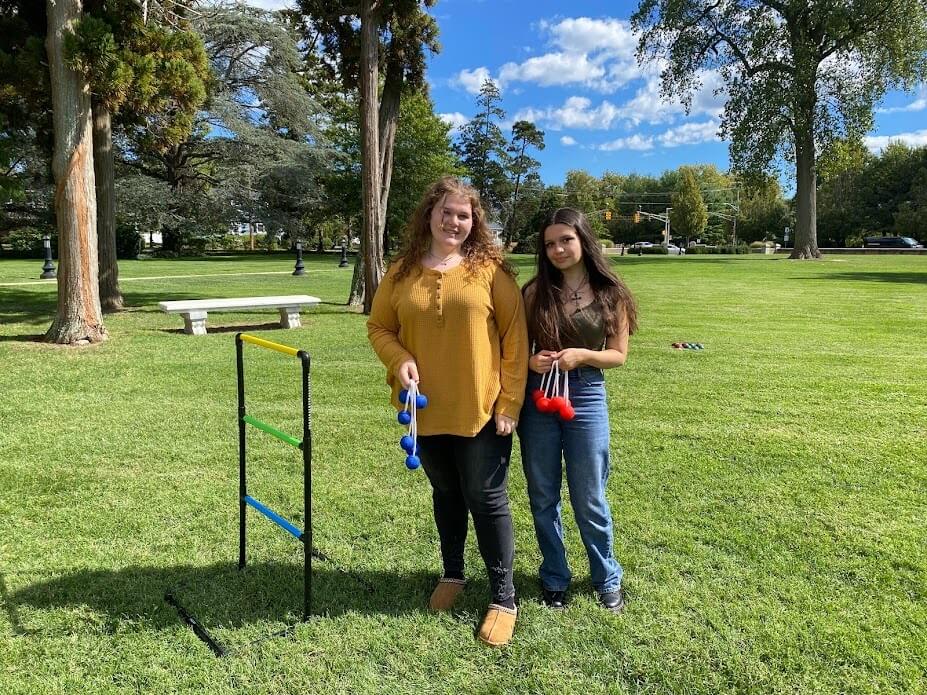 two students playing ladder golf on the library lawn