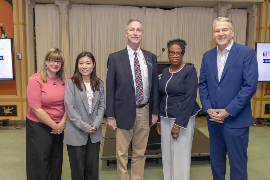 Five speakers standing for a portrait