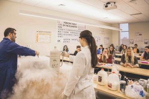 Lecturer mixing chemicals in front of a captive audience of students