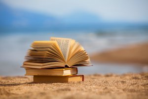 A stack of books on the sands of a beach
