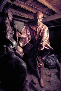 A man leaning on a cane and holding his open hand out forward