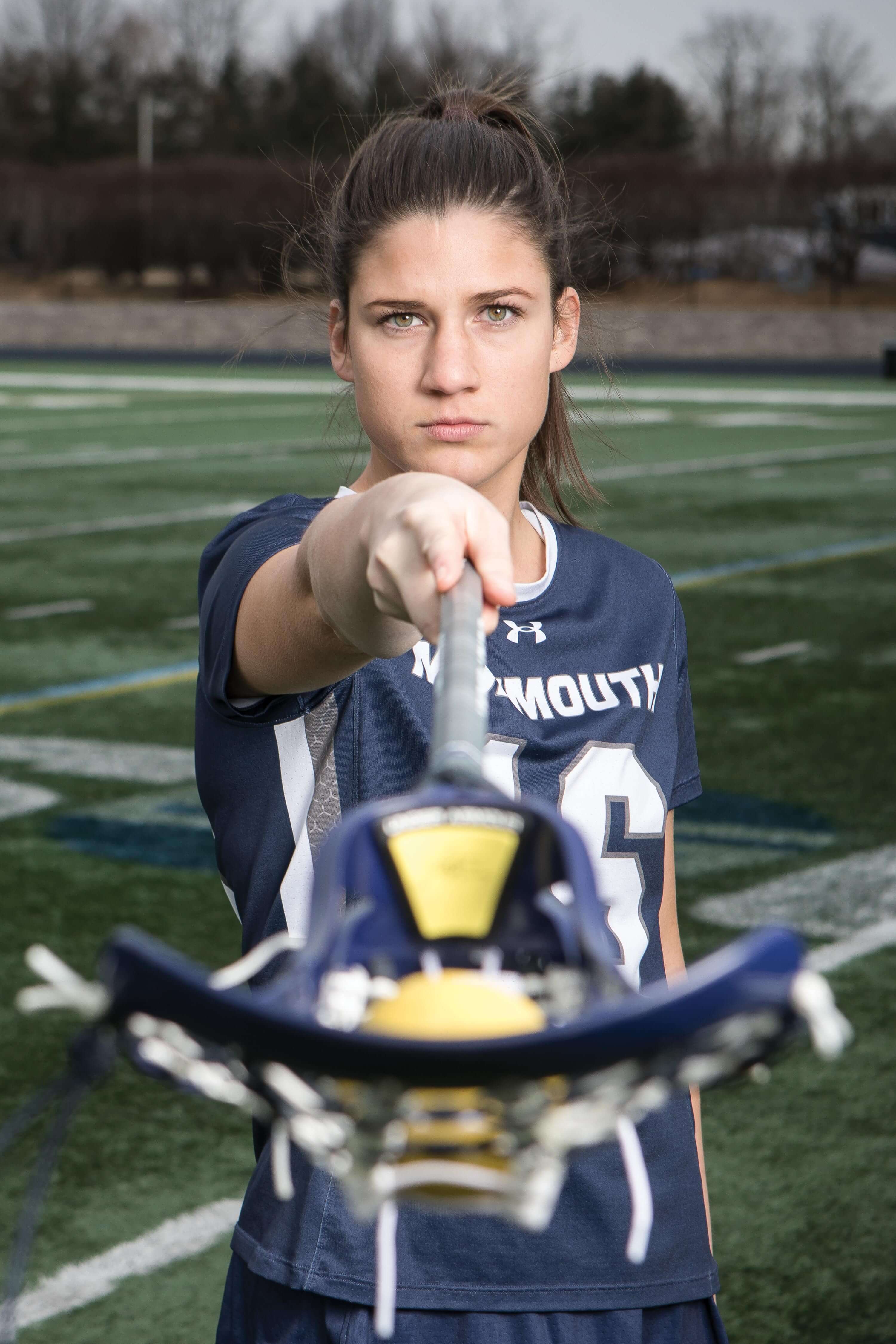 Megan Hart holding a crosse to the camera