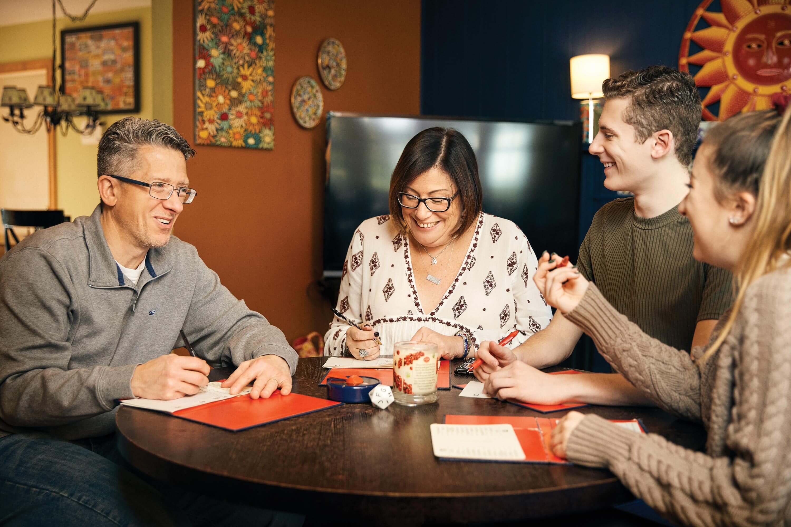 Melissa Surdez sitting at the kitchen table with her family, all smiles. 