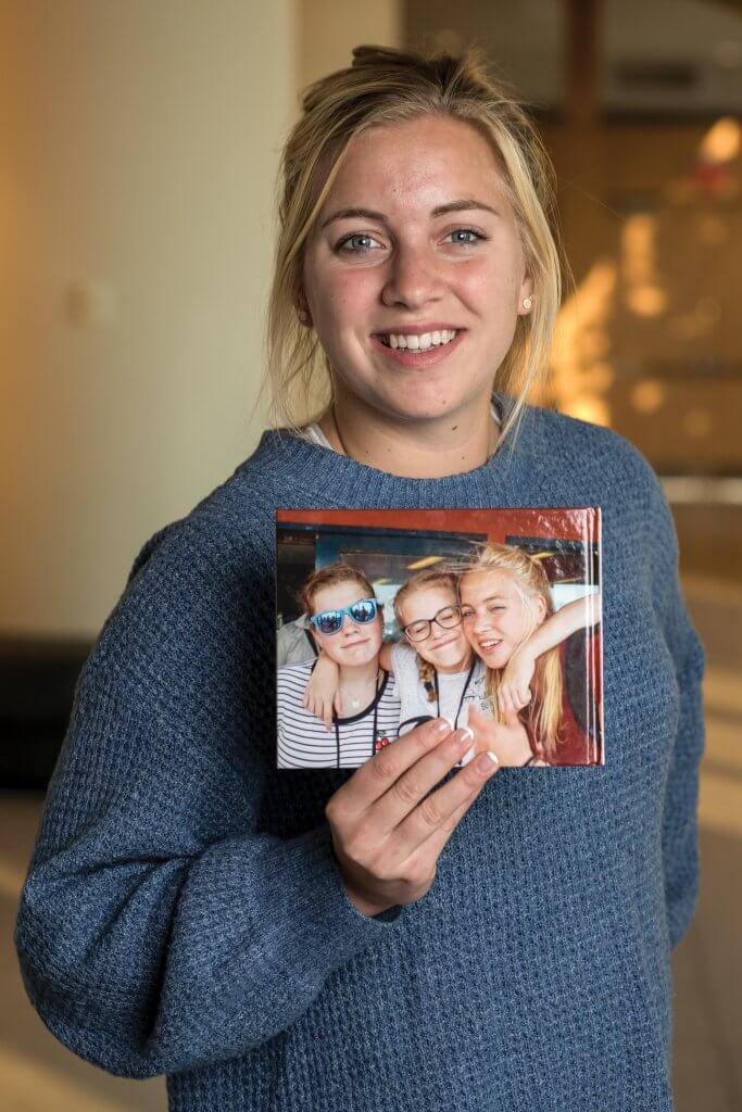 Josephine Van Der Hoop holding a photobook of her family's visit to Monmouth
