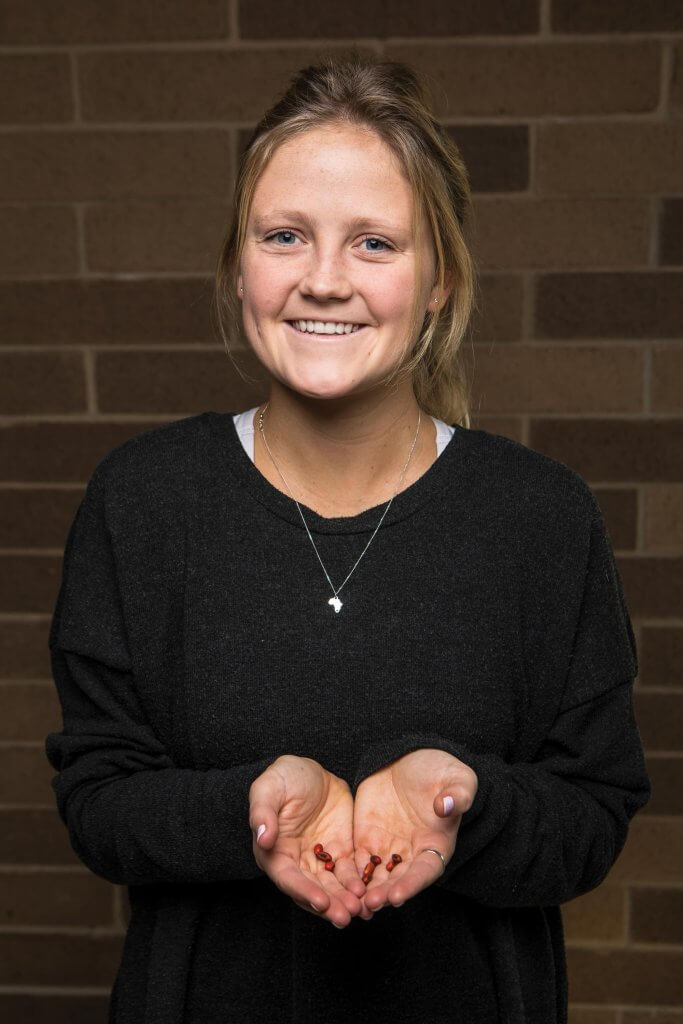 Megan De Lange holding coral tree seeds