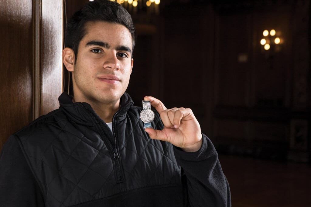 Sergio Martinez holding a silver bill clip engraved with the Mayan calendar