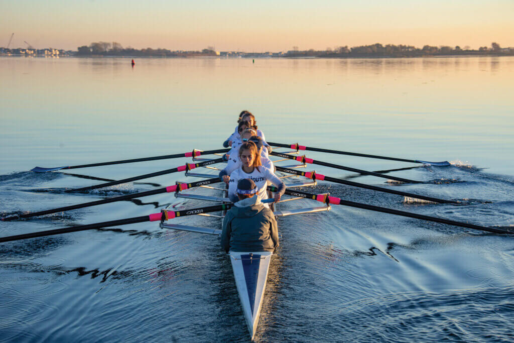A photo of 8 Monmouth rowers in a boat on the water.