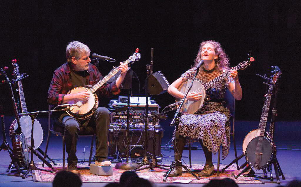 two musicians play banjo on stage