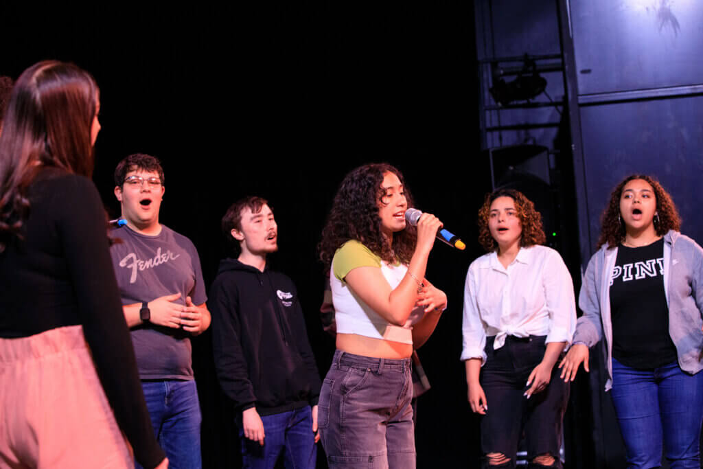 students singing a cappella on stage