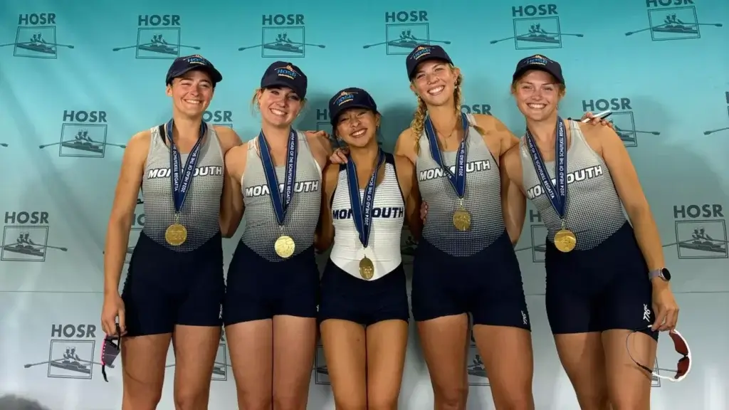 Five women's rowers pose with gold medals