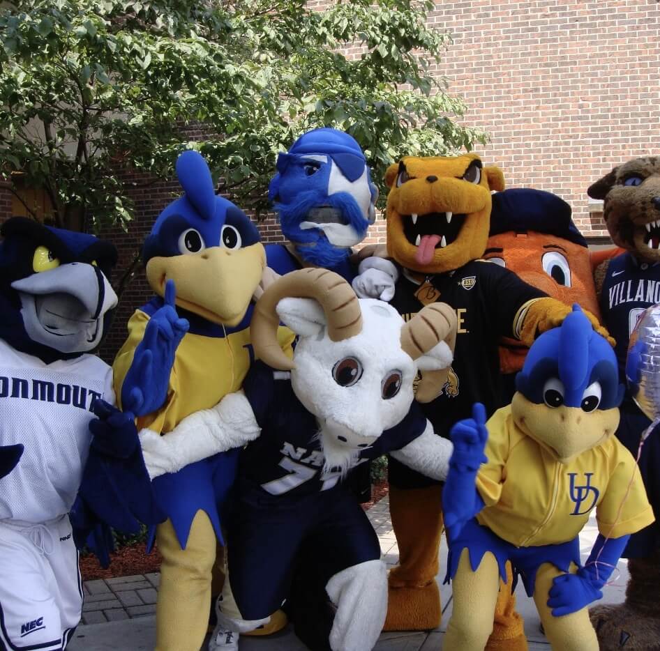 A group of college mascots, including Monmouth University’s Shadow the Hawk, pose together outdoors