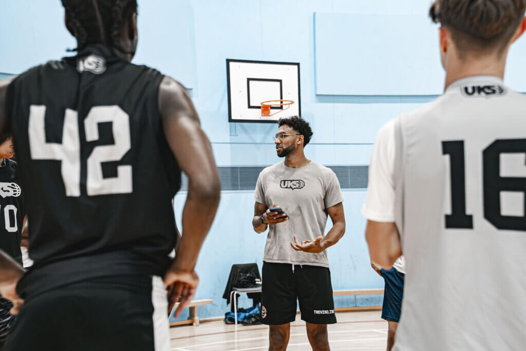 Basketball coach Daniel James ’13 speaks to players during practice