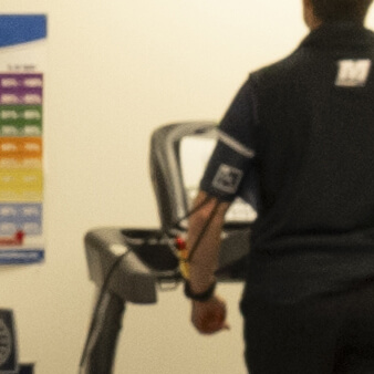 closeup of A person walking on a treadmill wearing a wireless motion tracker