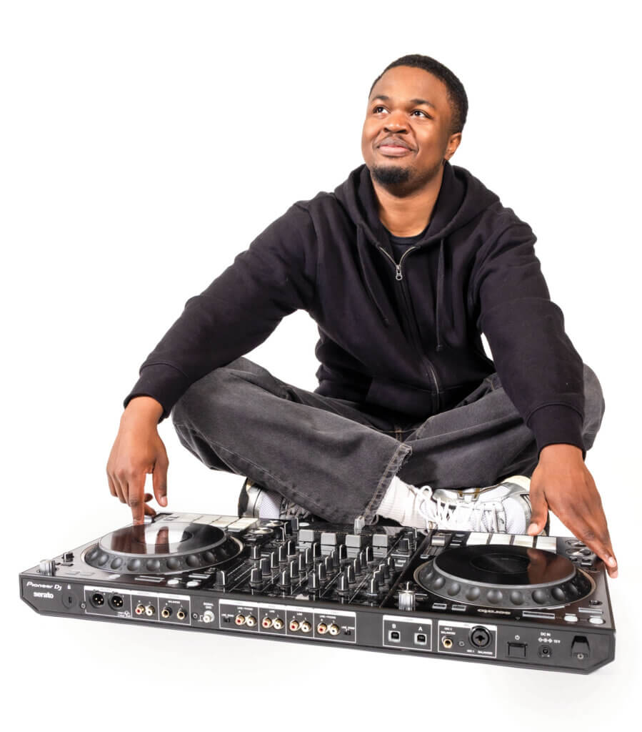 Victor Davidson sits behind DJ equipment