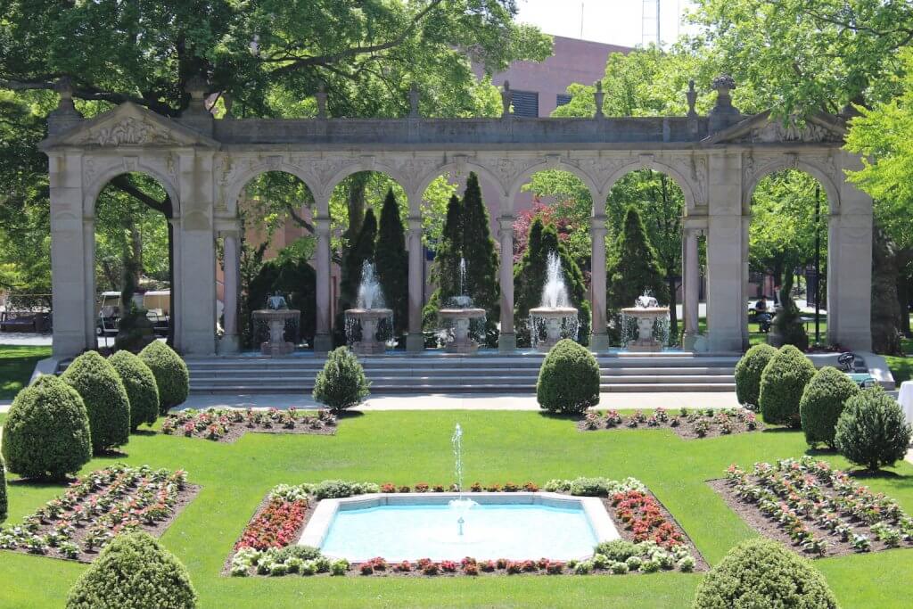 Erlanger Gardens, with fountains shooting upwards. The plants and bushes are arranged in the garden.