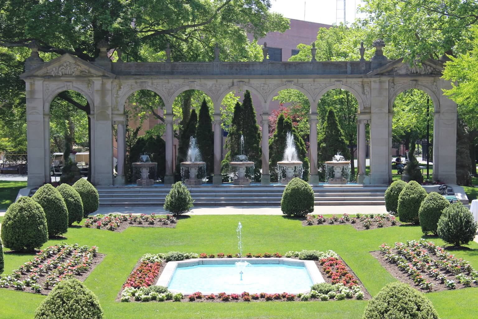 Erlanger Gardens, with fountains shooting upwards. The plants and bushes are arranged in the garden.