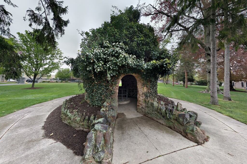Photo showcasing The Well, with leaves adoring the roof of the structure