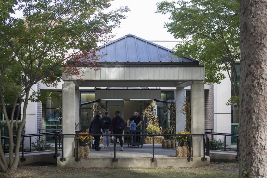 Workers and students leaving and entering the doors of the Samuel Hays Magill Commons