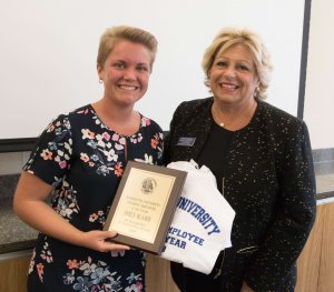 A photo of Emily Blaser holding a plaque and shirt with Patricia Swannack pictured right.