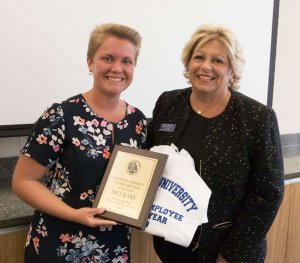 A photo of Emily Blaser holding a plaque and shirt with Patricia Swannack pictured right. 