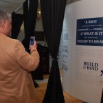 Photo shows visitor taking photograph of exhibit