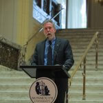Photo shows Monmouth University President Grey Dimenna addressing speaking at unveiling