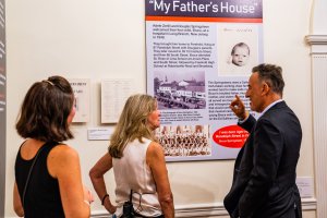 A photo of Bruce Springsteen talking about a poster he is looking at with Melissa Ziobro, Eileen Chapman