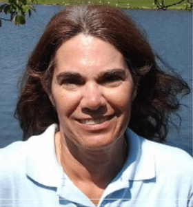 A headshot of Robyn Holmes with a lake or river in the background