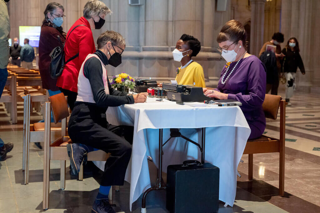 two typists take dictation at a table set up in the National Cathedral