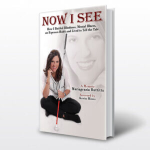 The front of the cover shows Mariagrazia sitting down and smiling while holding a white cane. She is wearing black pants and a white and black long sleeve dress shirt. In the background is a zoomed picture of Mariagrazia’s face.