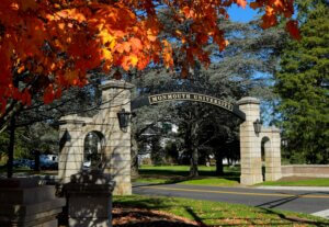 Gates of Monmouth University amidst fall foliage
