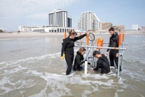 Students in wetsuits doing research in ocean water near Atlantic CIty