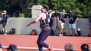 Man in athletic attire facing left is preparing to throw a javelin