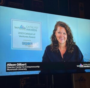 Photo of Alison Gilbert projected on stage/screen indicating selection as Catalyst award winner