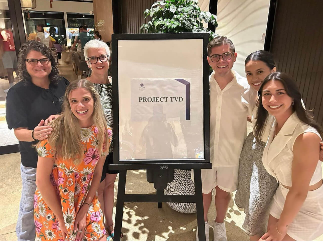 Students and faculty pose around a poster