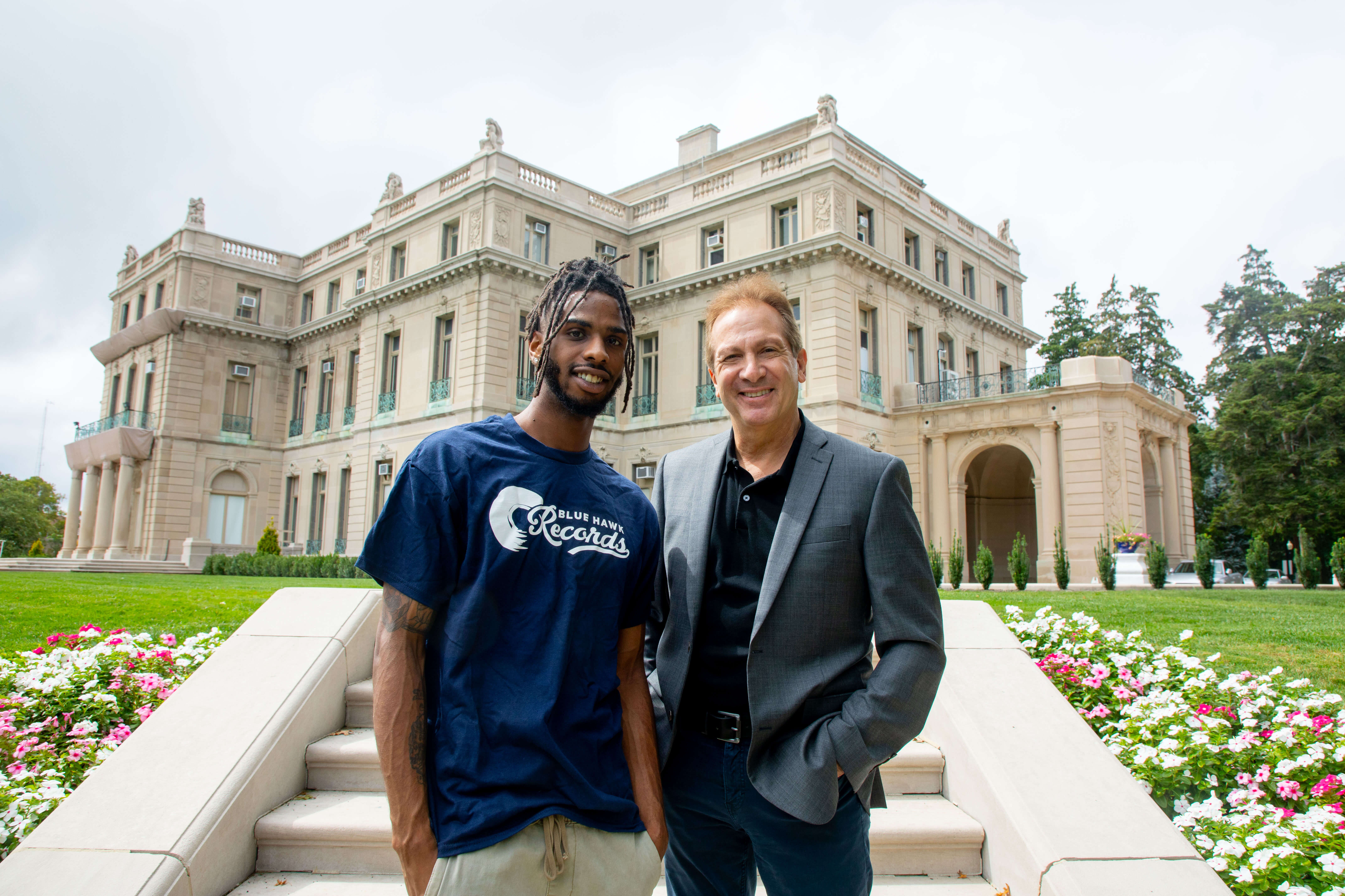Asad Whitehead, a senior music industry student, and Joe Rapolla, specialist professor and chair of the Department of Music and Theatre Arts, in front of the Great Hall.