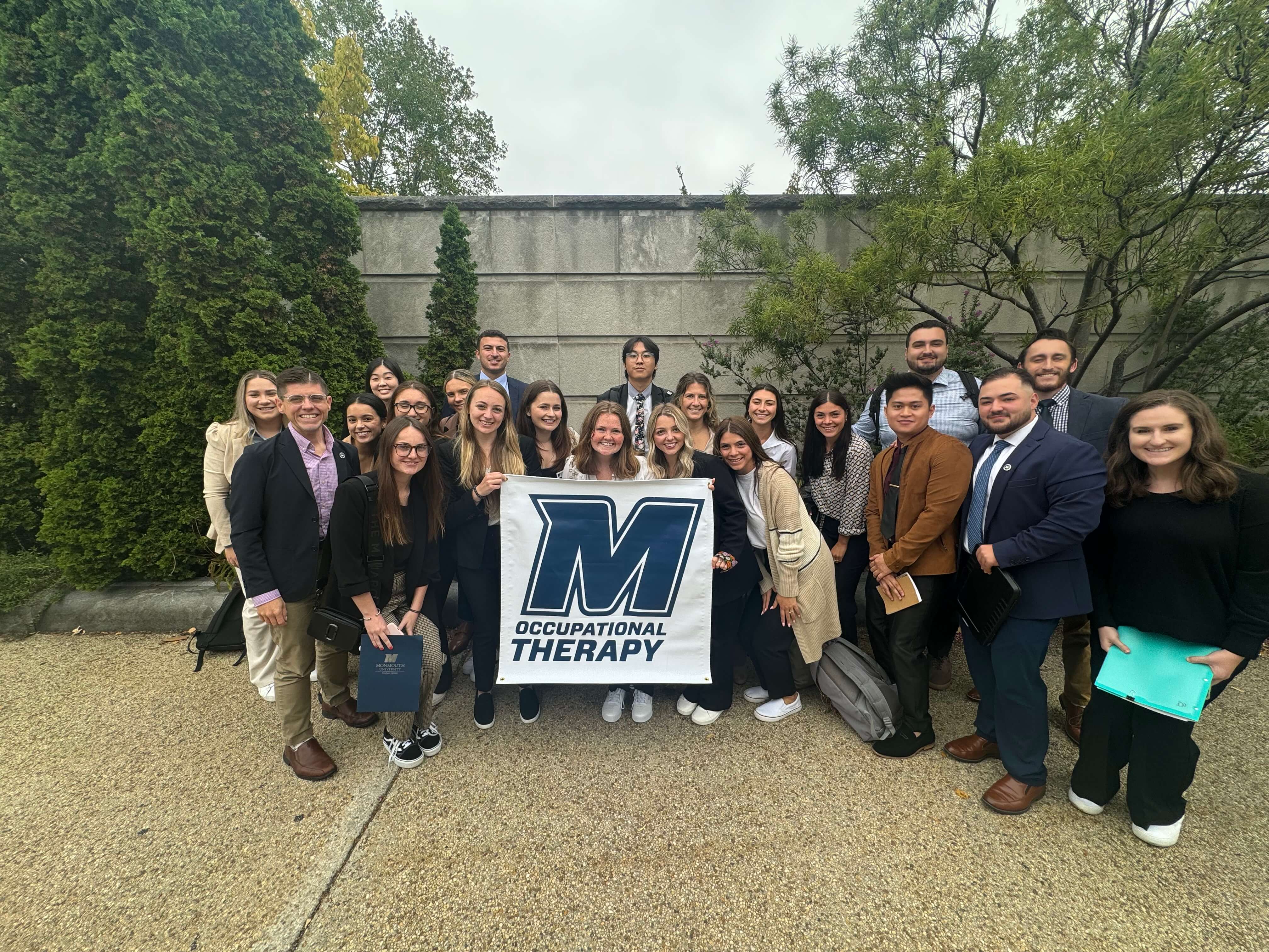 Monmouth OTD Students visit Washing ton DC, holding banner for Occupational Therapy program