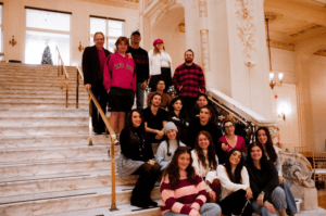 Student members of Blue Hawk Records sit on staircase in Monmouth University's Great Hall
