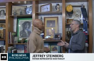 Alumnus Jeffrey Steinberg shows Bob Marley artifact to reporter