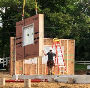 Construction worker assembling carbon neutral home for Prof. John Burke