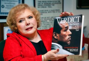 Monmouth alumna Linda Deutsch holds a copy of her book, Verdict, chronicling the OJ Simpson Trial