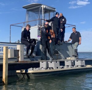 Divers and marine related people next to boat on dock