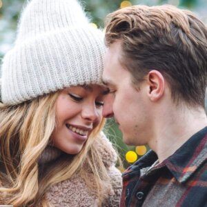woman in knit hat and man share intimate moment
